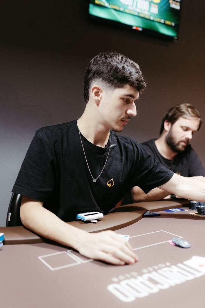 Mastering the First Impression: Your intriguing post title goes here Two men intensely playing poker at a casino table, strategizing their next move.