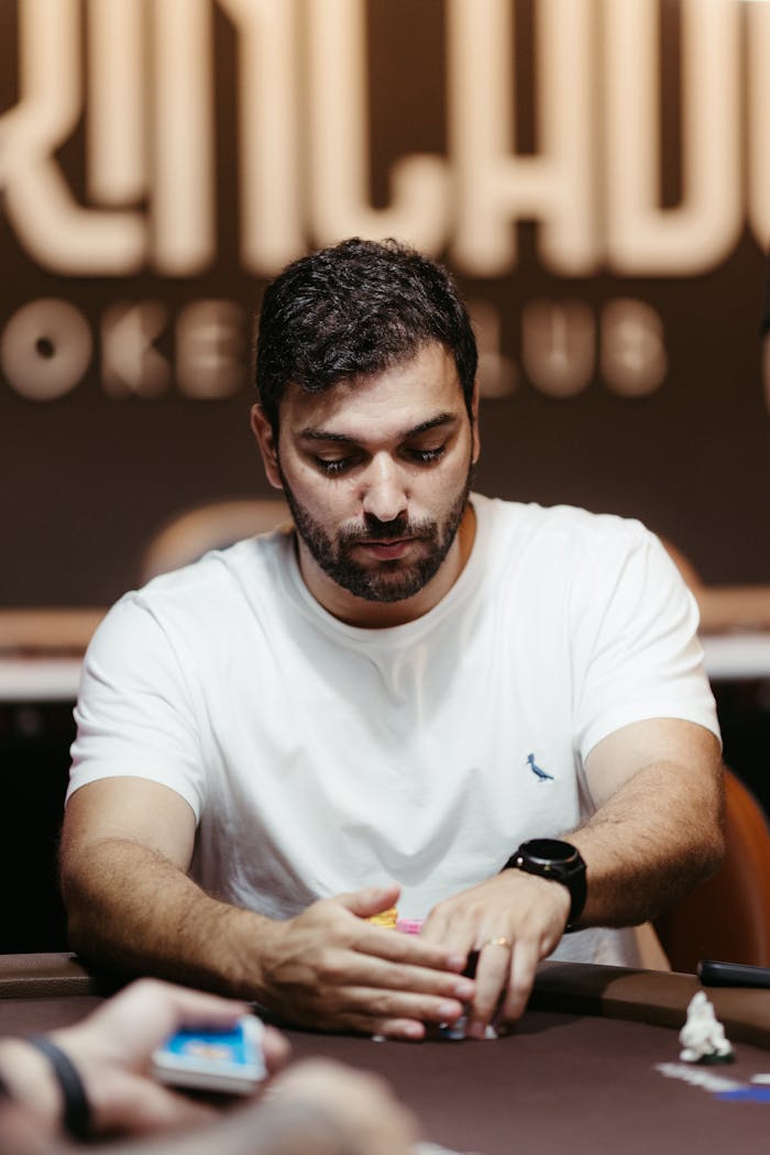 home-hero A man intensely concentrating during a poker game in a casino setting.