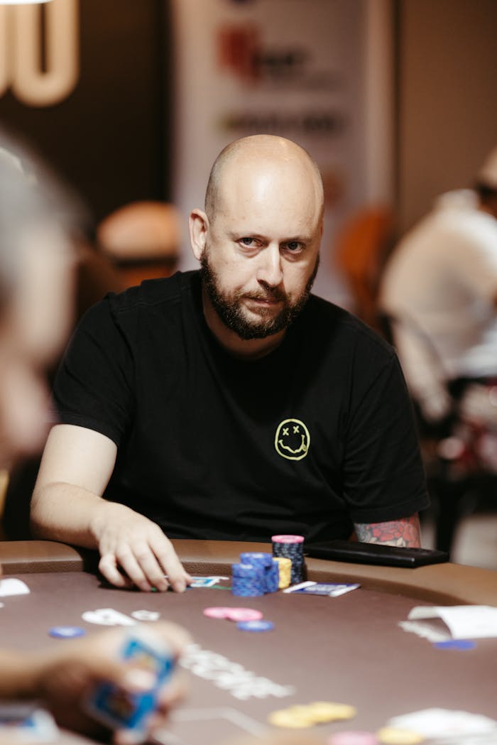 The Art of Drawing Readers In: Your attractive post title goes here A poker player intently strategizes at an indoor table during a game.