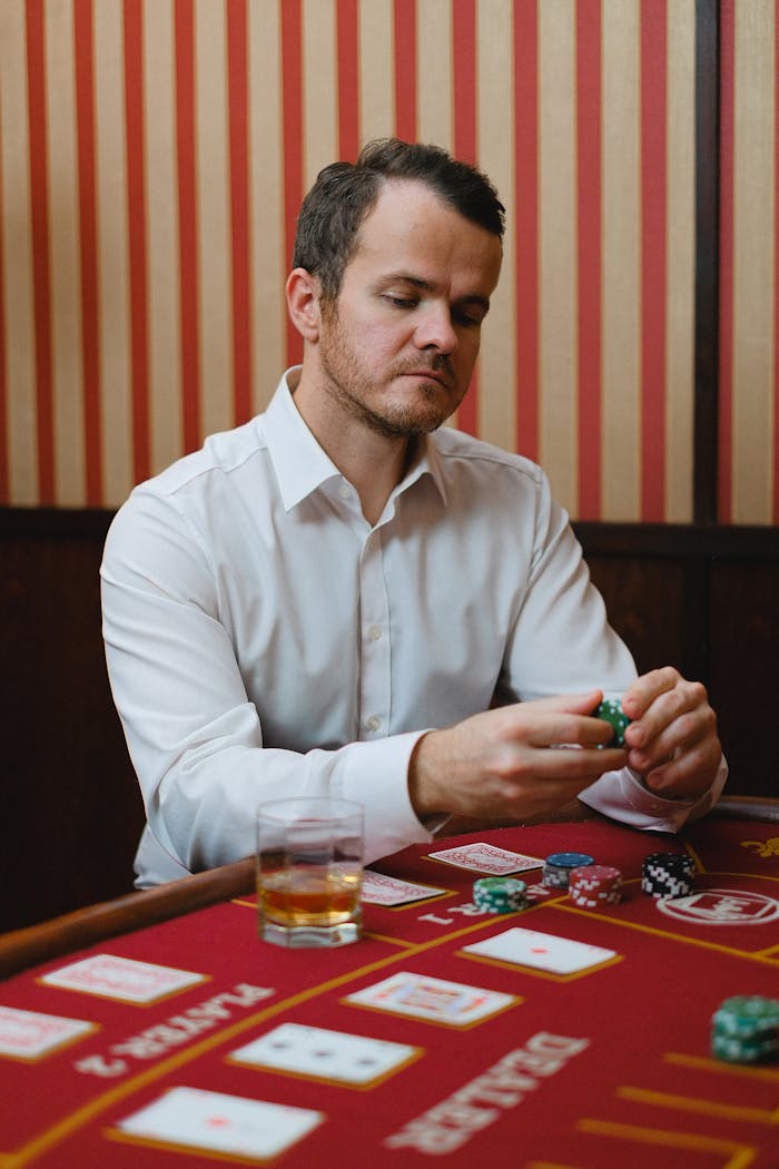 services-02 Adult man in a casino holding poker chips and focusing on the game.