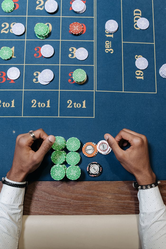 footer-cta Hands arranging chips on a roulette table in a casino setting.
